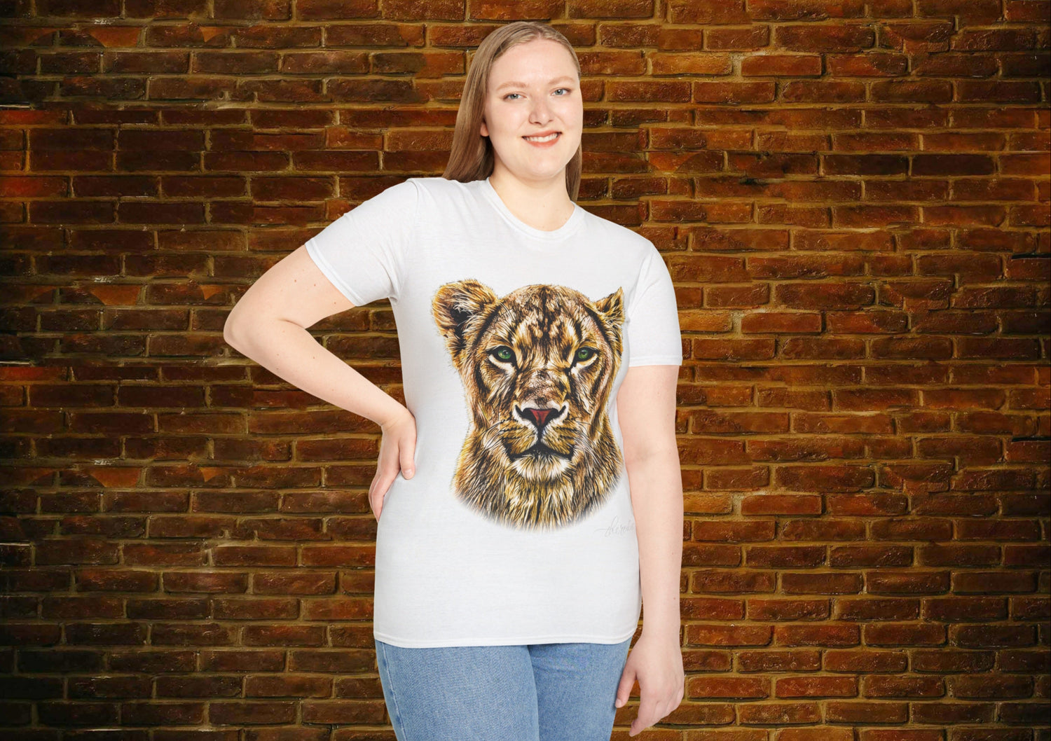 Person wearing a white t-shirt with a graphic of a lion's face against a brick wall.