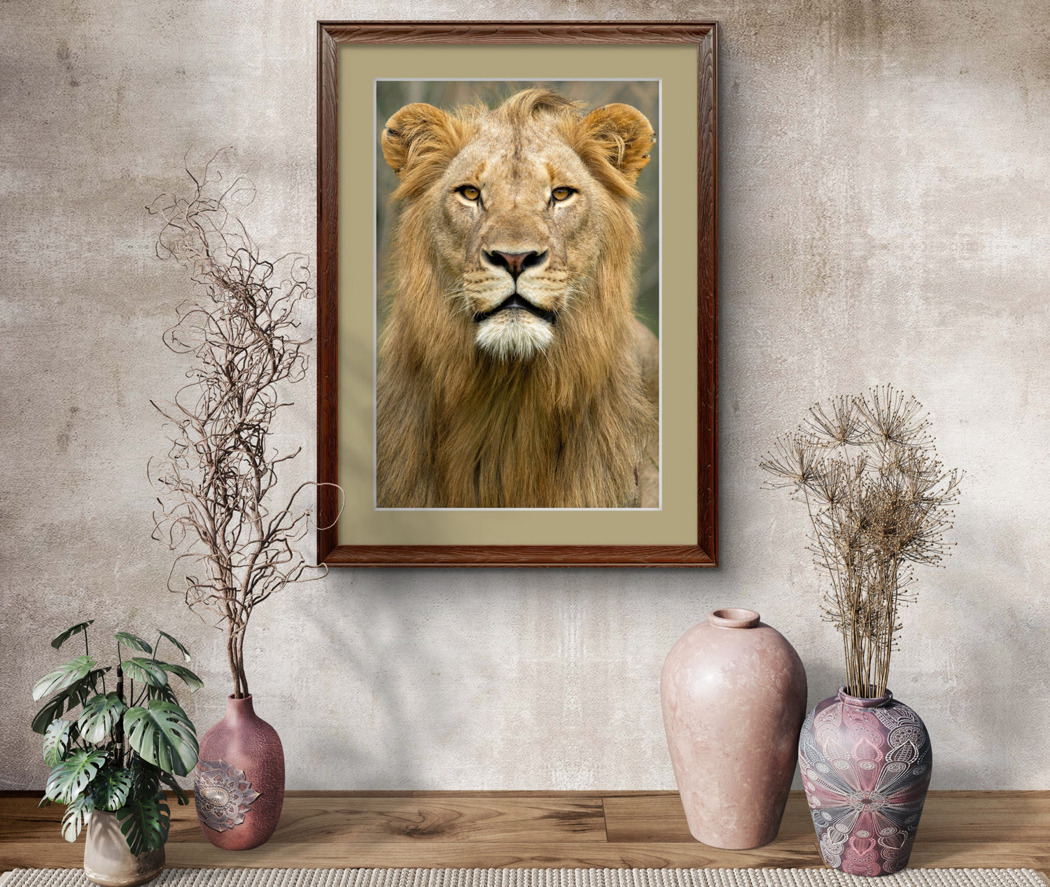 Framed portrait of a lion on a wall with decorative vases and plants below.